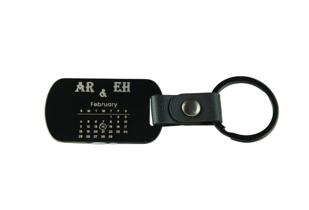 Black leather keychain with engraved text on a white background