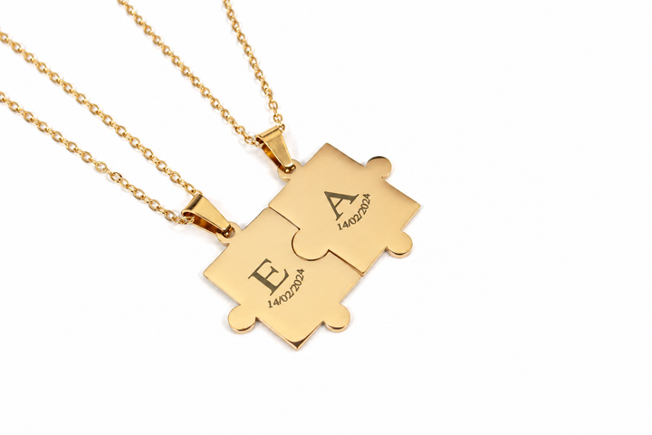 Two gold puzzle-piece necklaces with engraved letters &