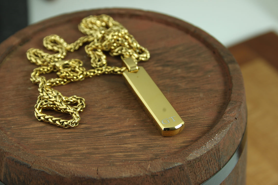 Gold necklace with a tag on a wooden surface