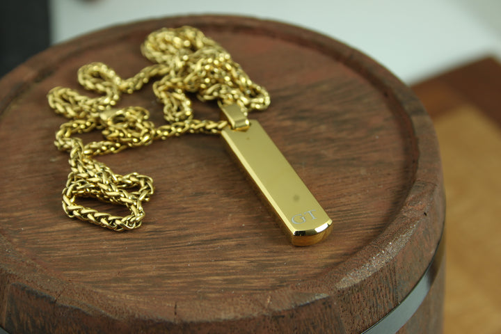 Gold necklace with a tag on a wooden surface