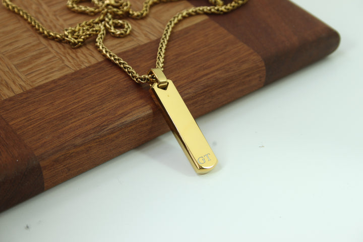 Gold necklace with a pendant on a wooden surface
