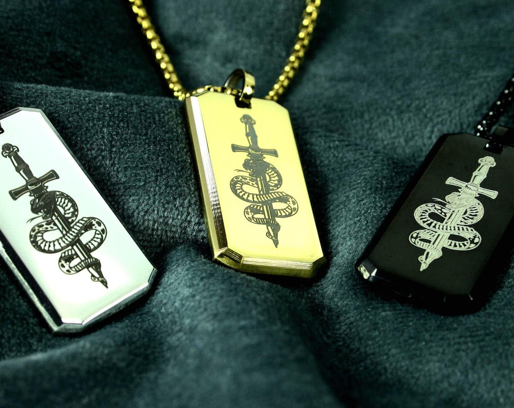 Three dog tags with different designs on a dark background