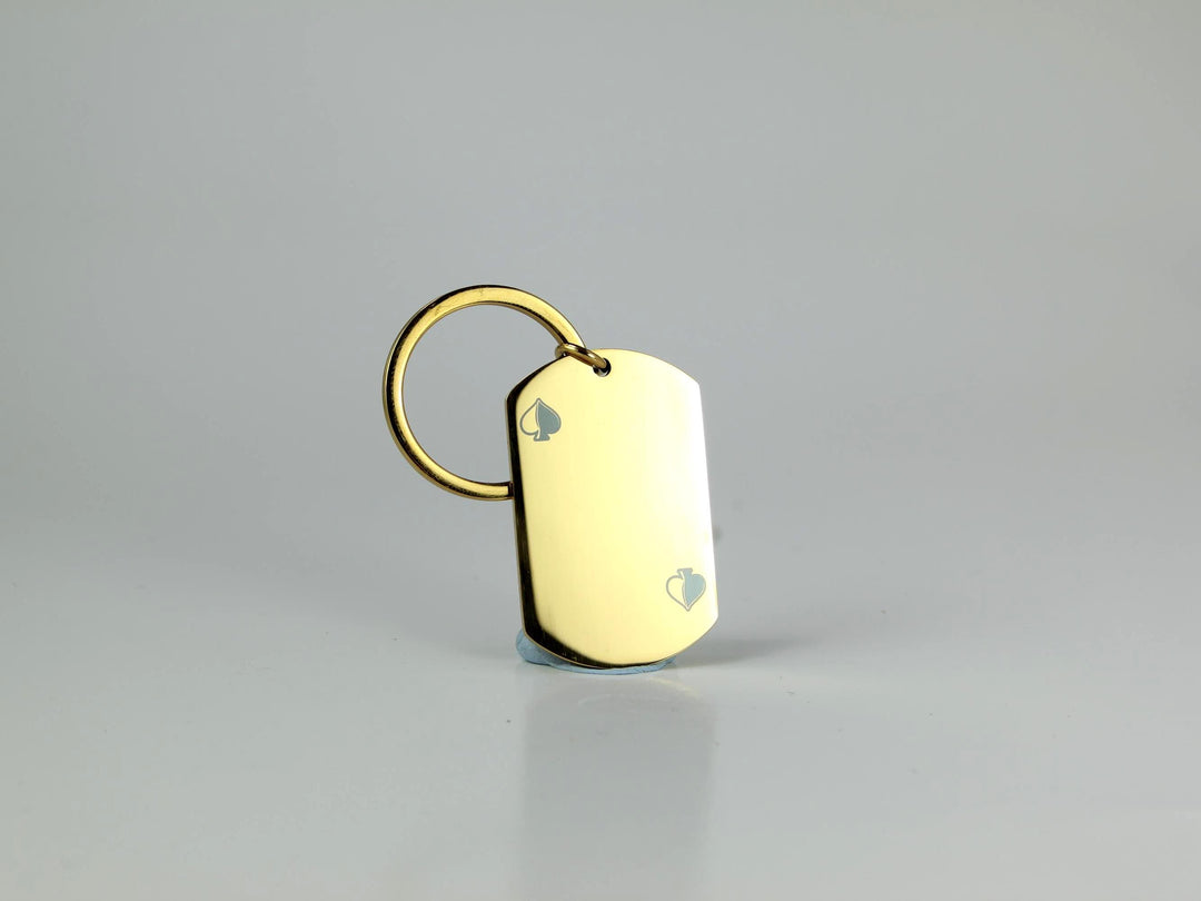 Gold dog tag keychain on a gray background