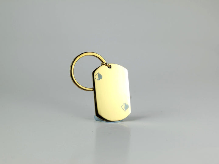 Gold dog tag keychain on a gray background