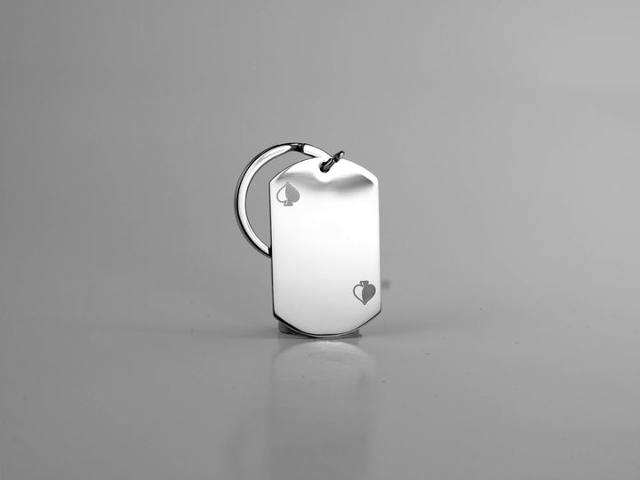 Silver dog tag with heart engraving on a gray background
